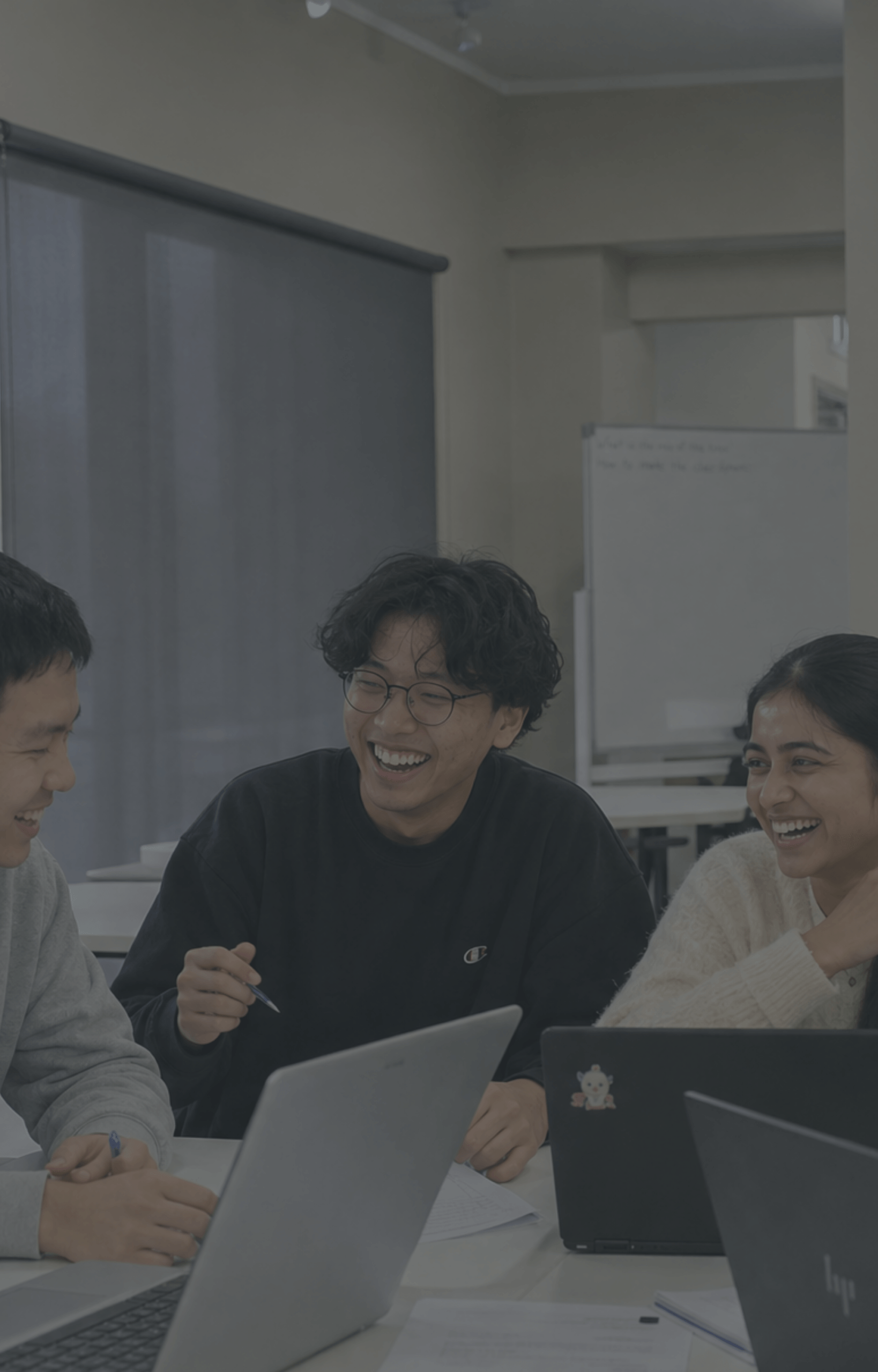 asian-south-asian-young-adults-laptops-classroom-laughing-dark-overlay-nz